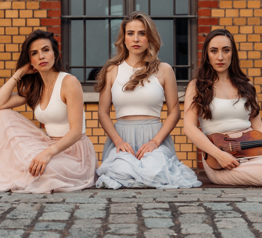 Foto von drei sitzenden Frauen mit Instrumenten